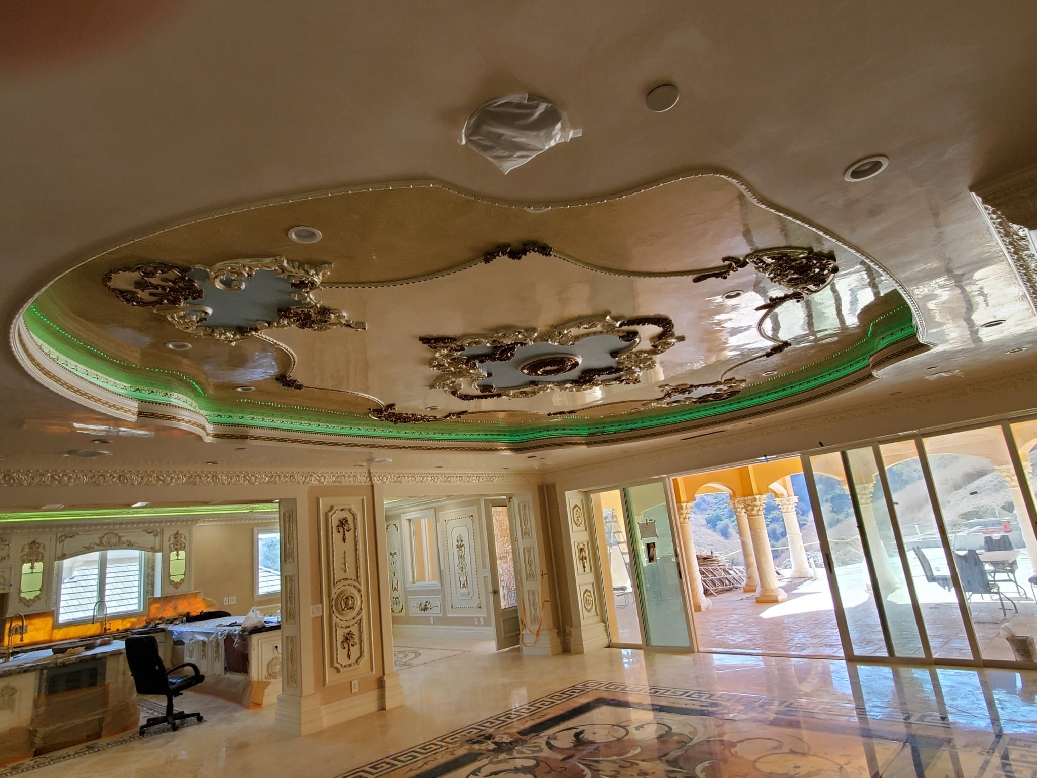 Luxurious interior with ornate ceiling design and large windows.